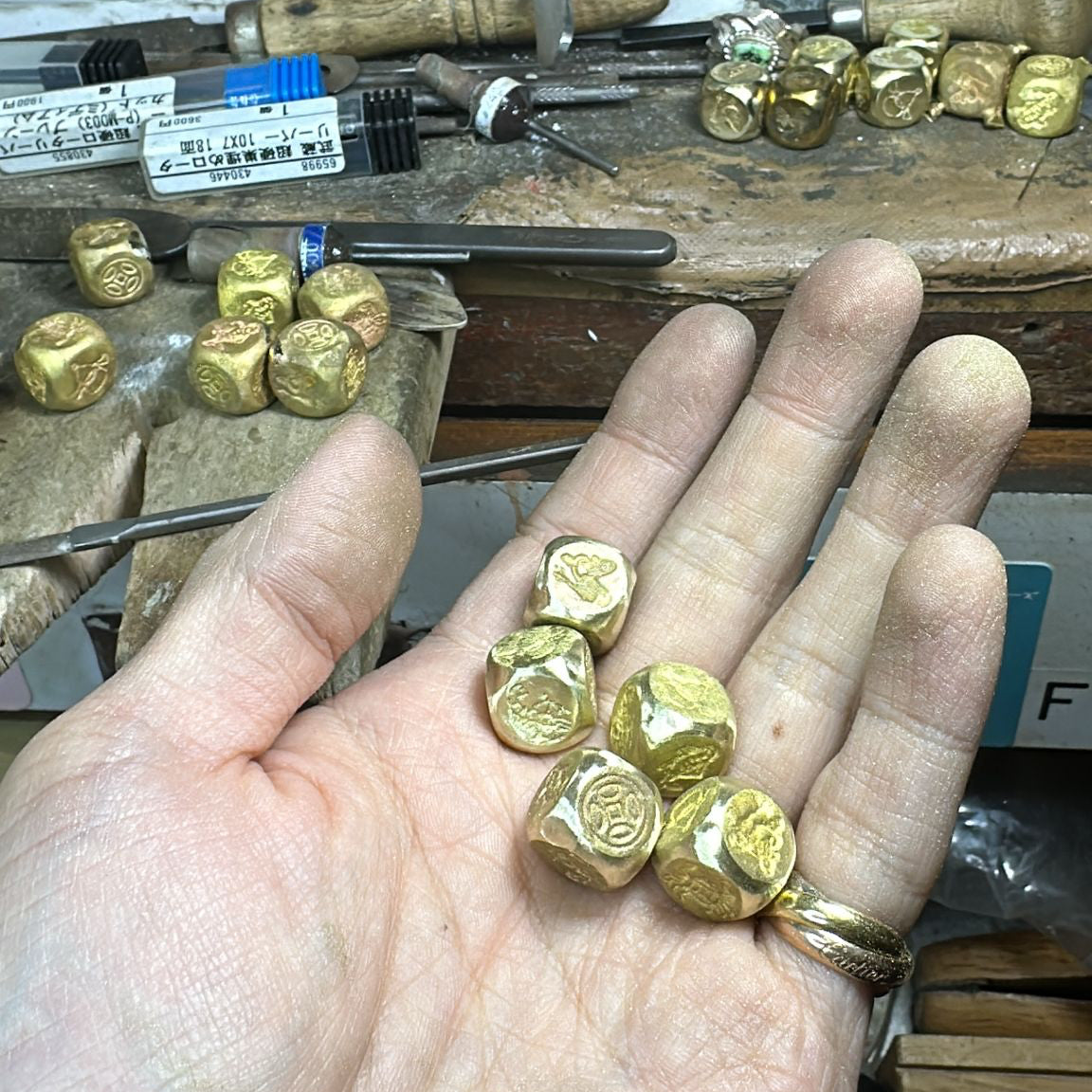 Close-up of handcrafted brass Fish-Prawn-Crab dice